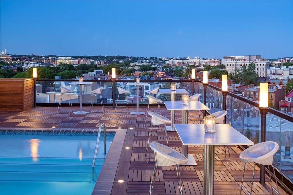 People socializing at Hush Rooftop Bar at Viceroy Washington DC with city skyline in background