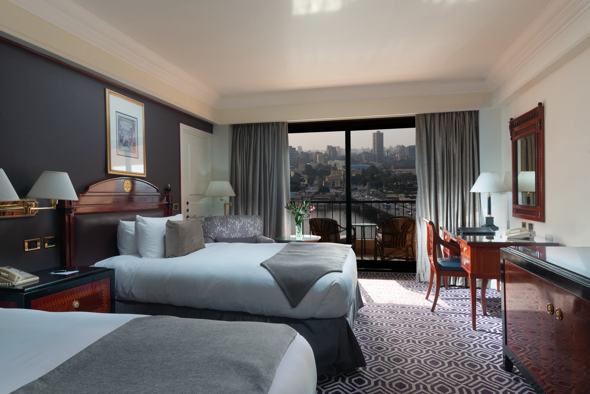 A private balcony at InterContinental Cairo Semiramis overlooking the Nile River and Cairo Tower at sunset.