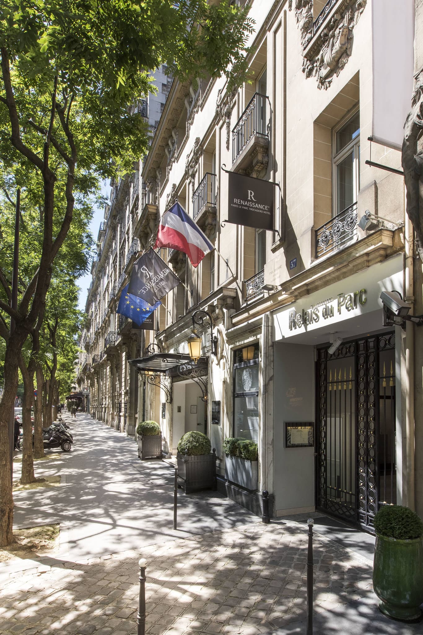 A lush, ivy-covered courtyard garden at Maison Revka with wrought-iron tables set for dinner.