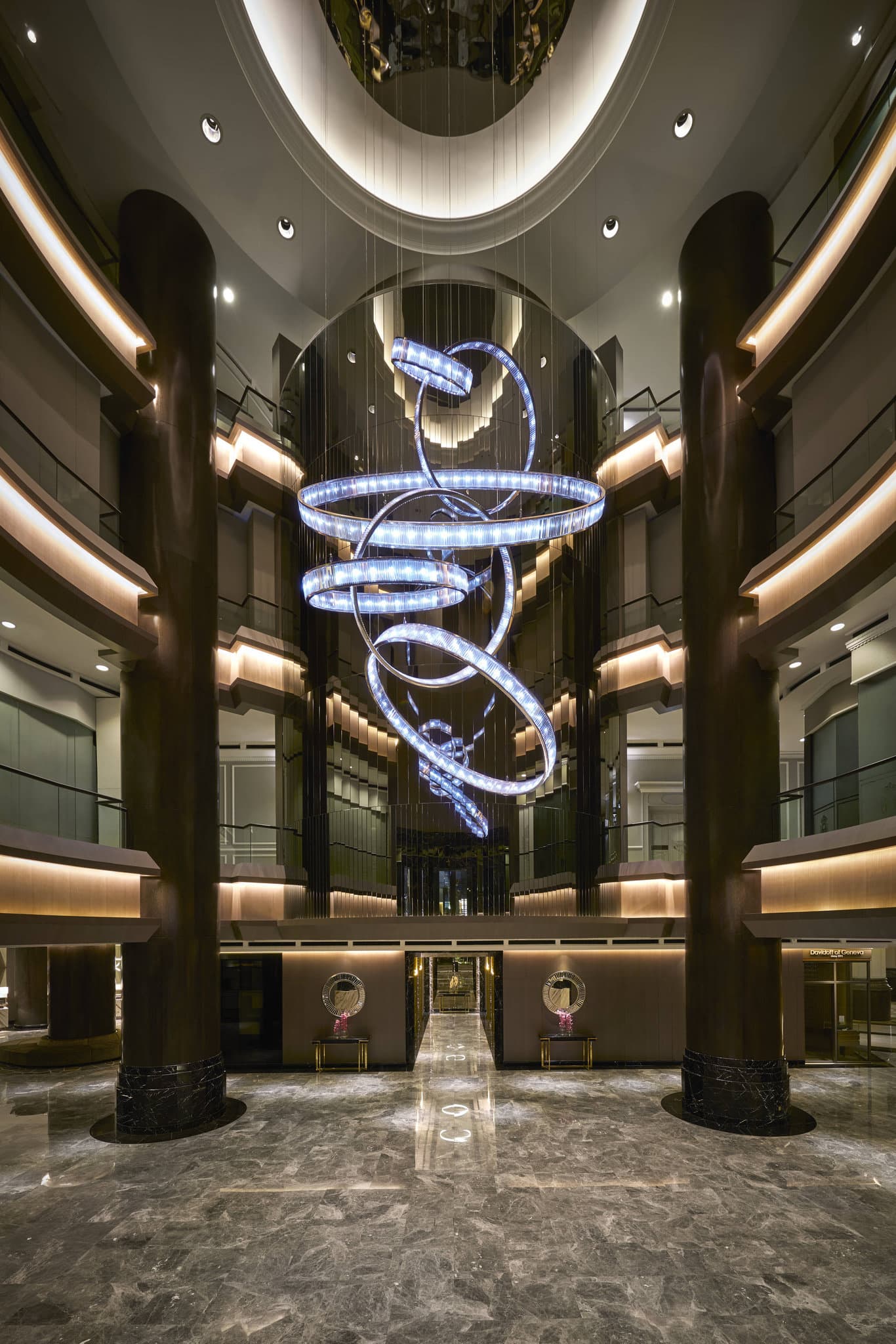 Lobby of JW Marriott Kuala Lumpur featuring a massive six-ring crystal chandelier and marble floors.