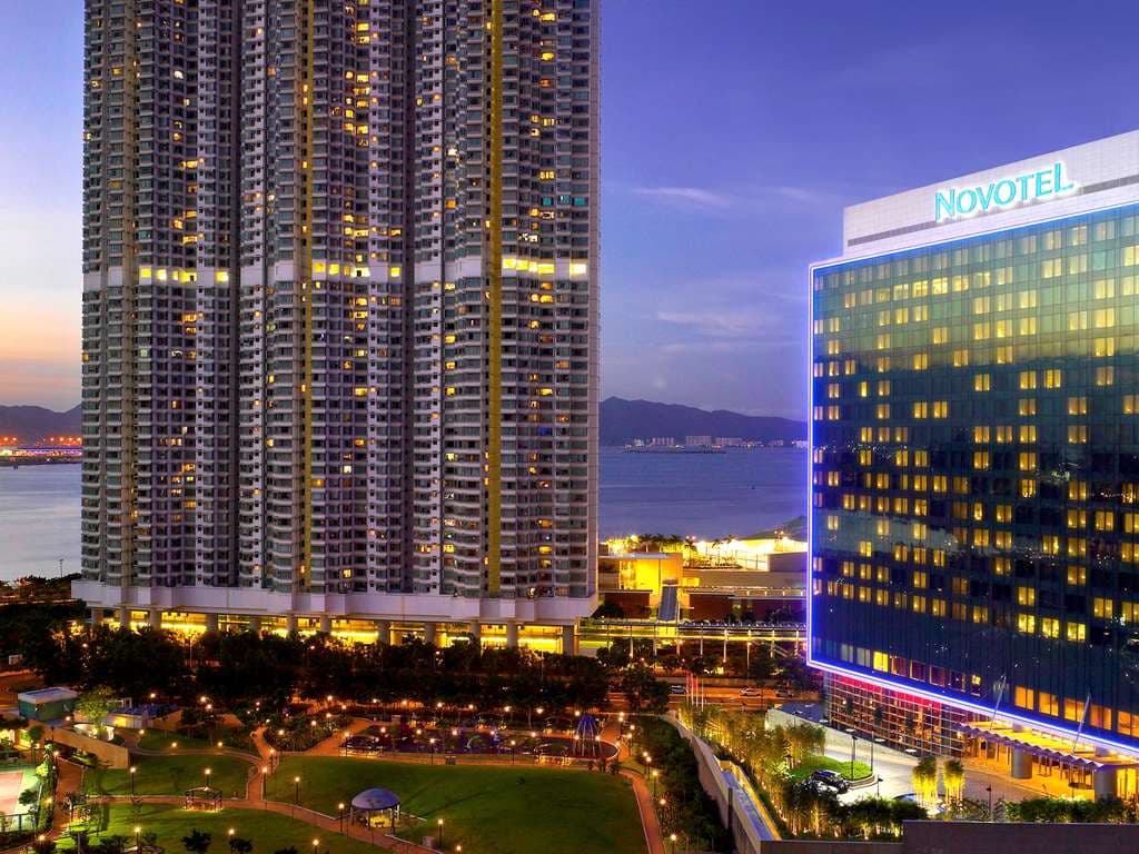 Novotel Citygate outdoor pool deck overlooking the Ngong Ping 360 cable cars and lush Lantau hills.