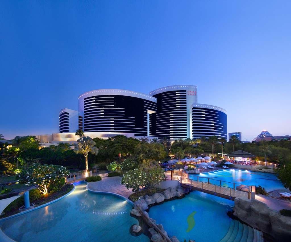 Grand Hyatt Dubai's massive indoor atrium garden featuring a traditional dhow boat and palm trees.