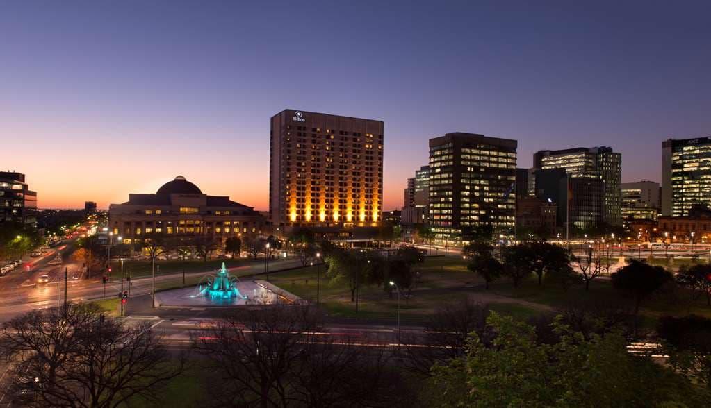 Hilton Adelaide outdoor heated pool with lounge chairs and city skyline views.