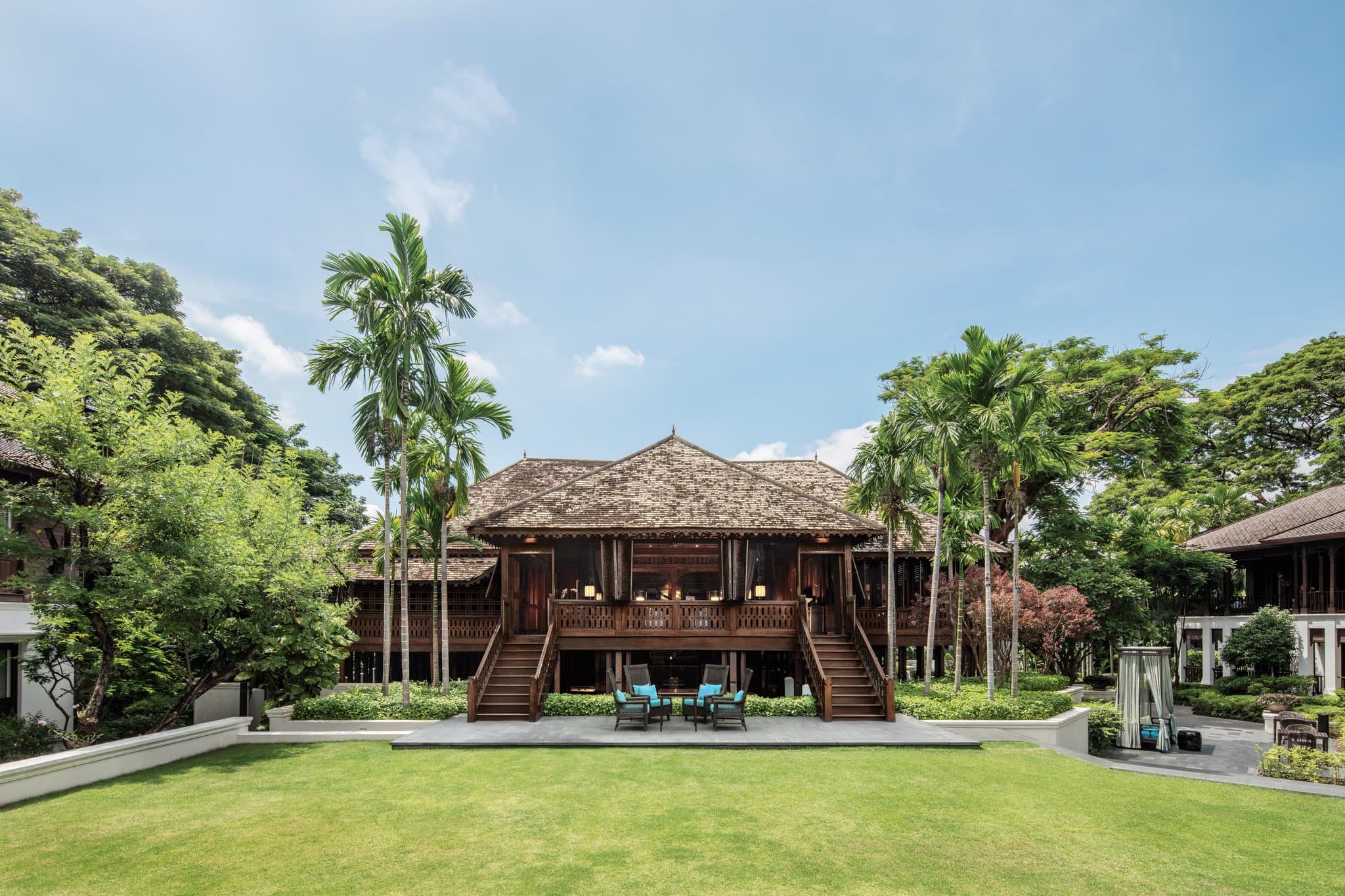 The iconic 25m lap pool at 137 Pillars House Chiang Mai framed by a towering vertical garden wall.