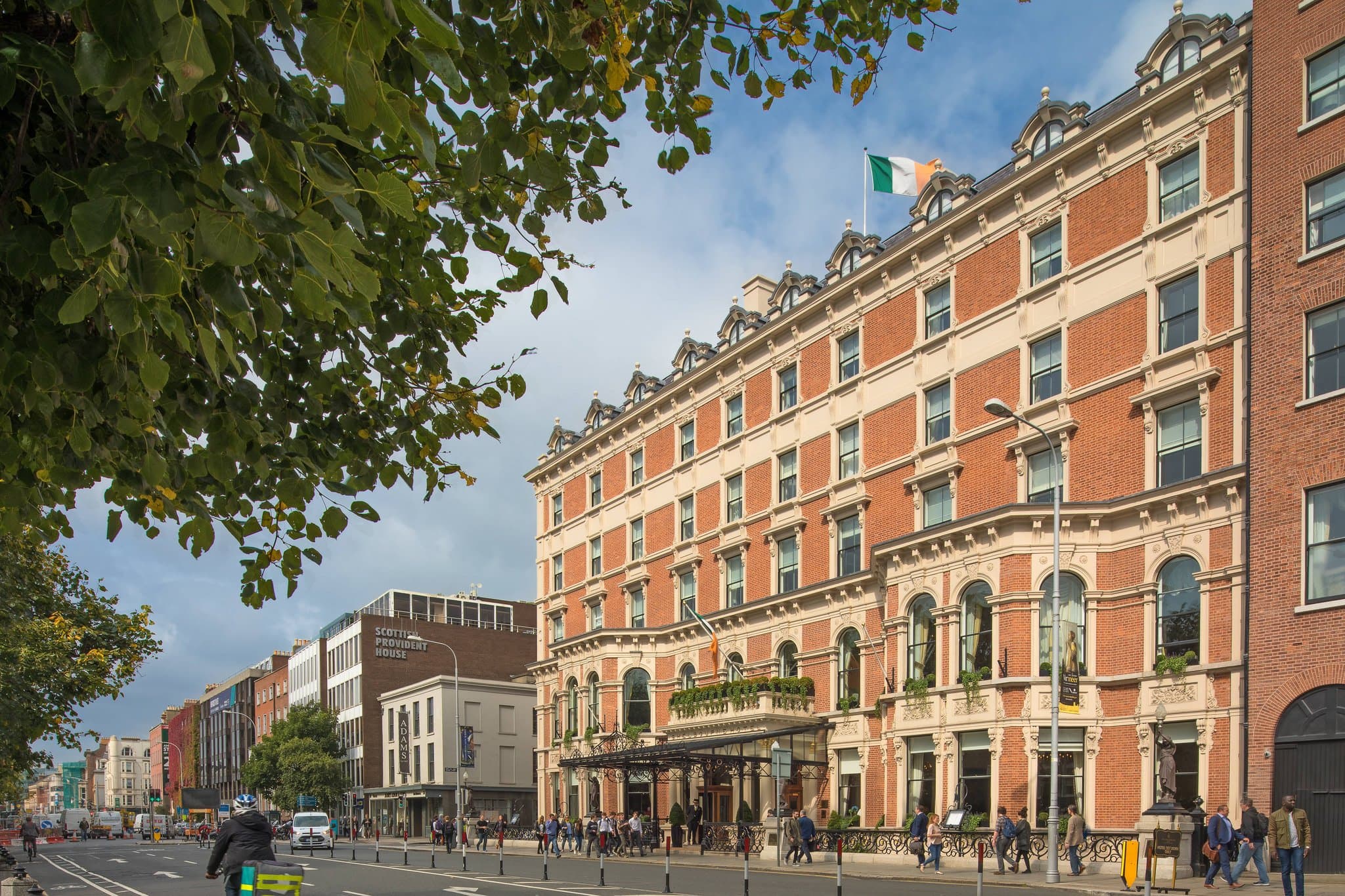The Shelbourne Hotel exterior facing St. Stephen's Green with red brick facade and top-hatted doormen.