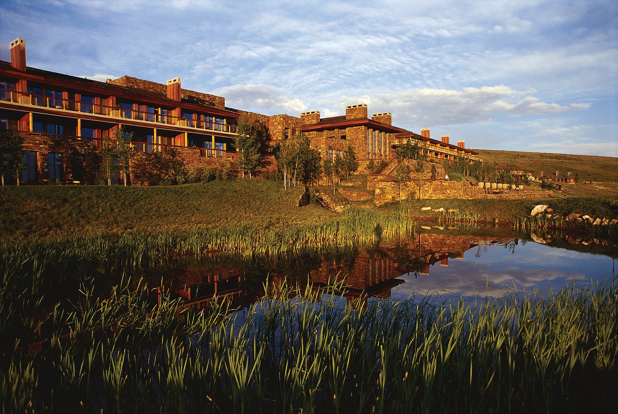 Amangani's 35m heated outdoor infinity pool overlooking the snow-capped Grand Teton mountains at sunset.