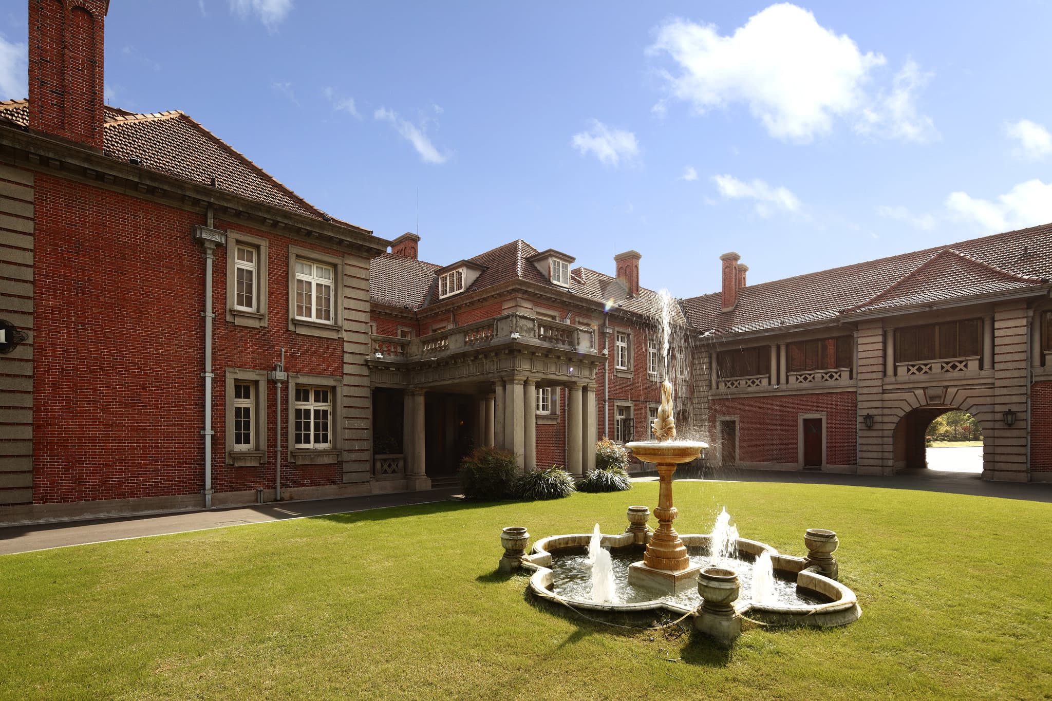 The red-brick facade of the 1917 Morris Residence at InterContinental Shanghai Ruijin surrounded by manicured English gardens.