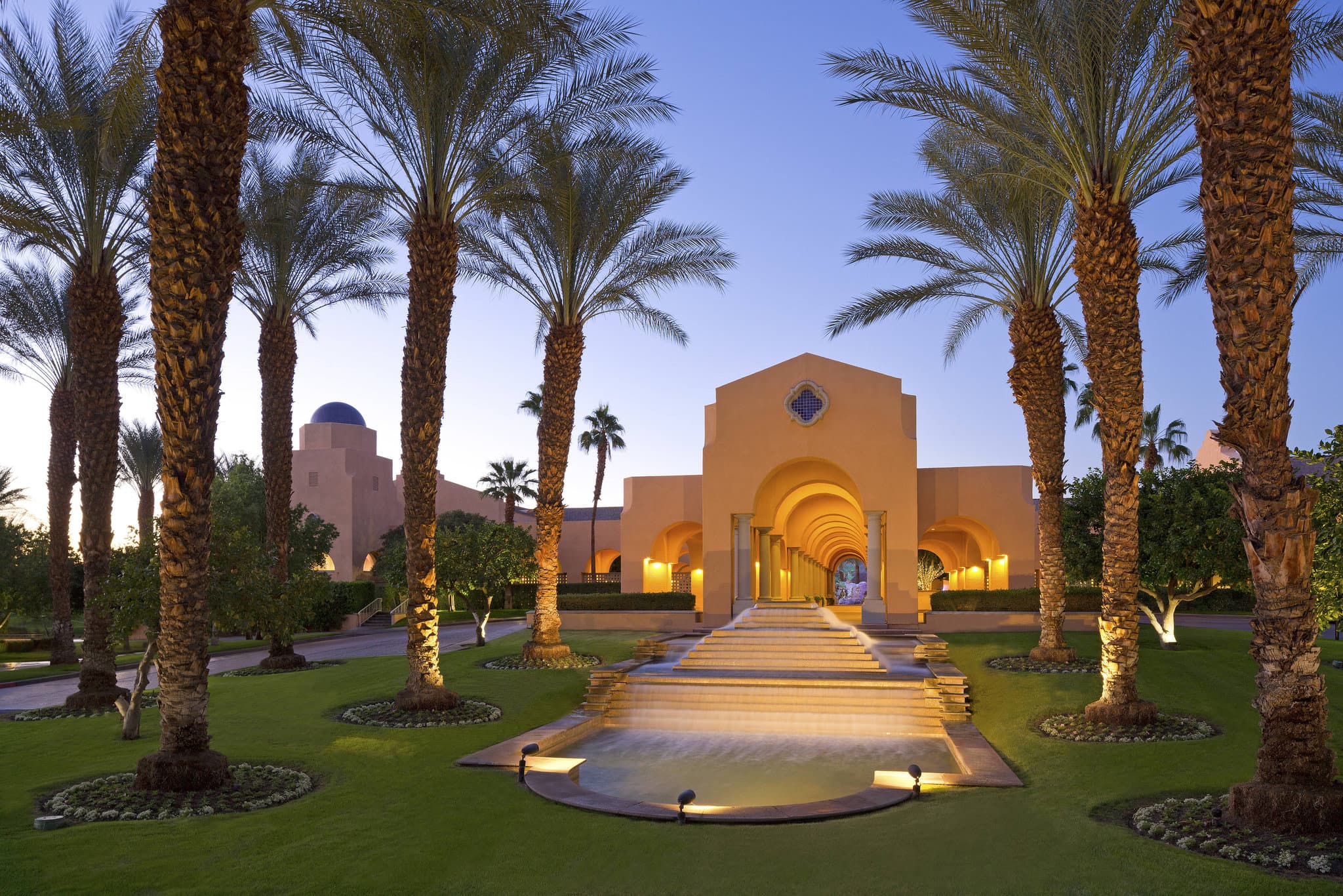 Las Brisas pool at Westin Rancho Mirage featuring dual 60-foot waterslides and palm trees at sunset.