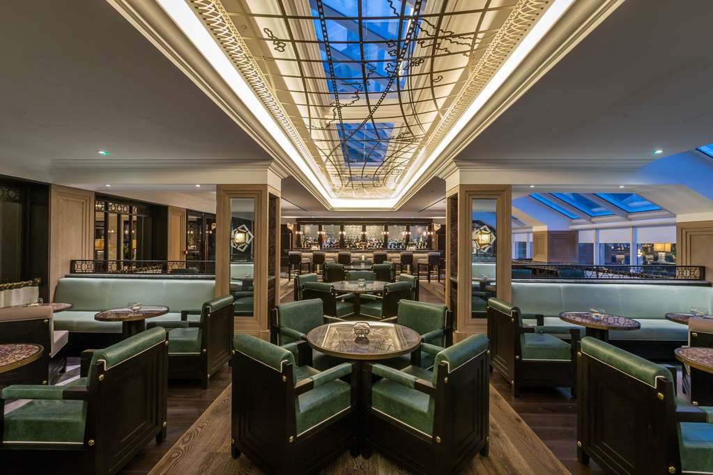 The Coburg restaurant interior featuring equestrian-themed leather banquettes and brass accents at Conrad Dublin.
