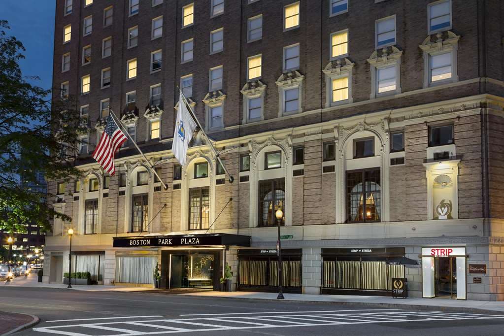 The soaring, chandelier-lit lobby of Hilton Boston Park Plaza with guests dining at Off The Common.