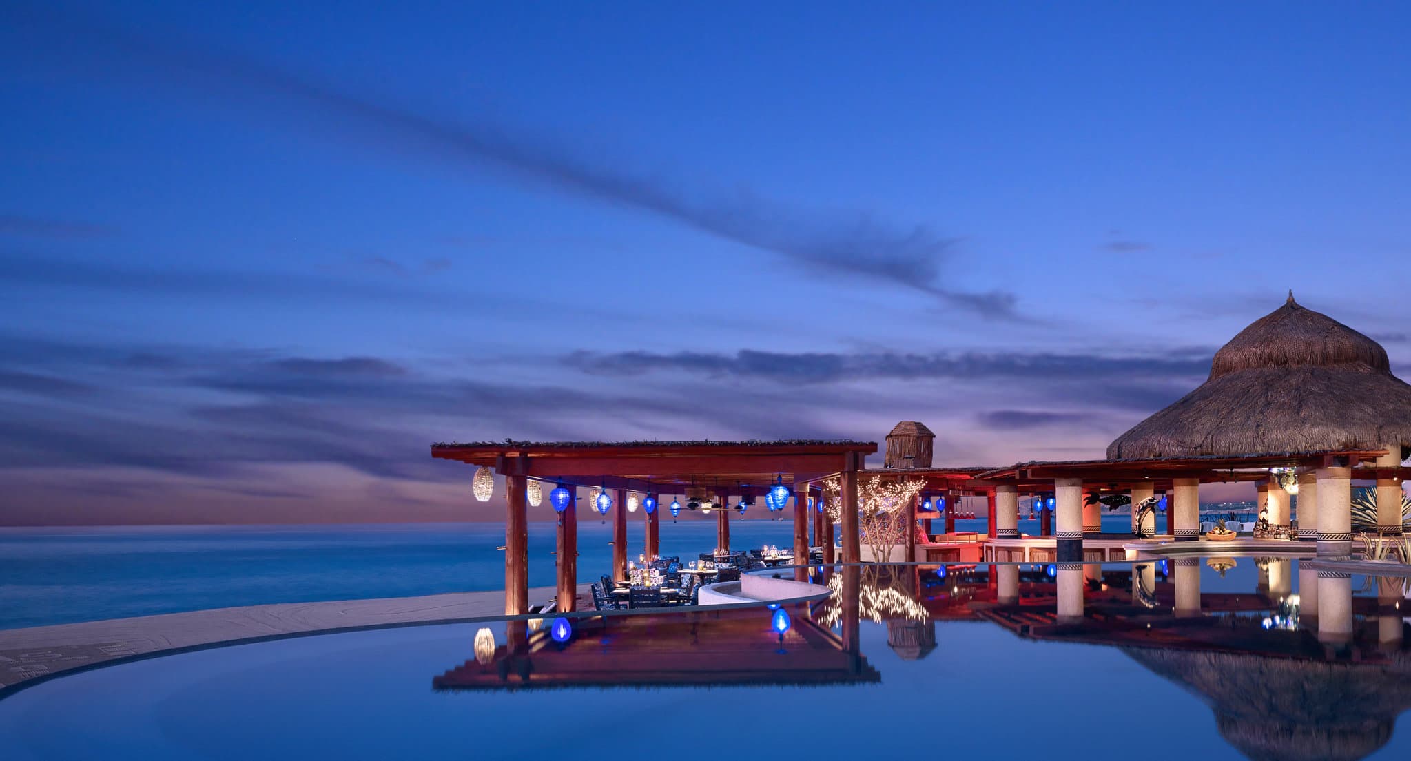 The infinity pool at Las Ventanas al Paraíso blending seamlessly with the Sea of Cortez at sunset, framed by white adobe architecture.
