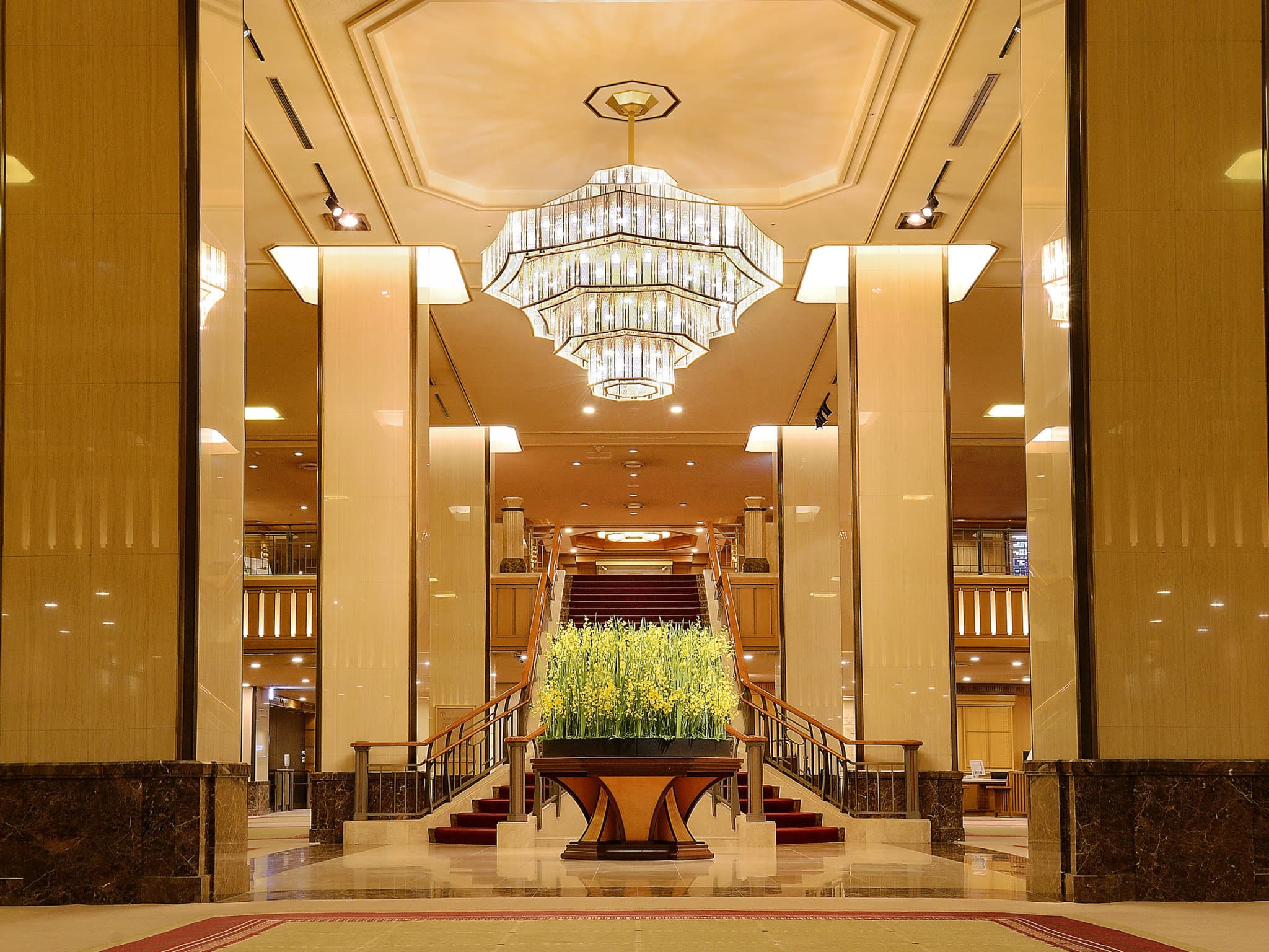 The Imperial Hotel Tokyo's main lobby featuring the iconic 'Golden Rose' chandelier and seasonal flower arrangement.