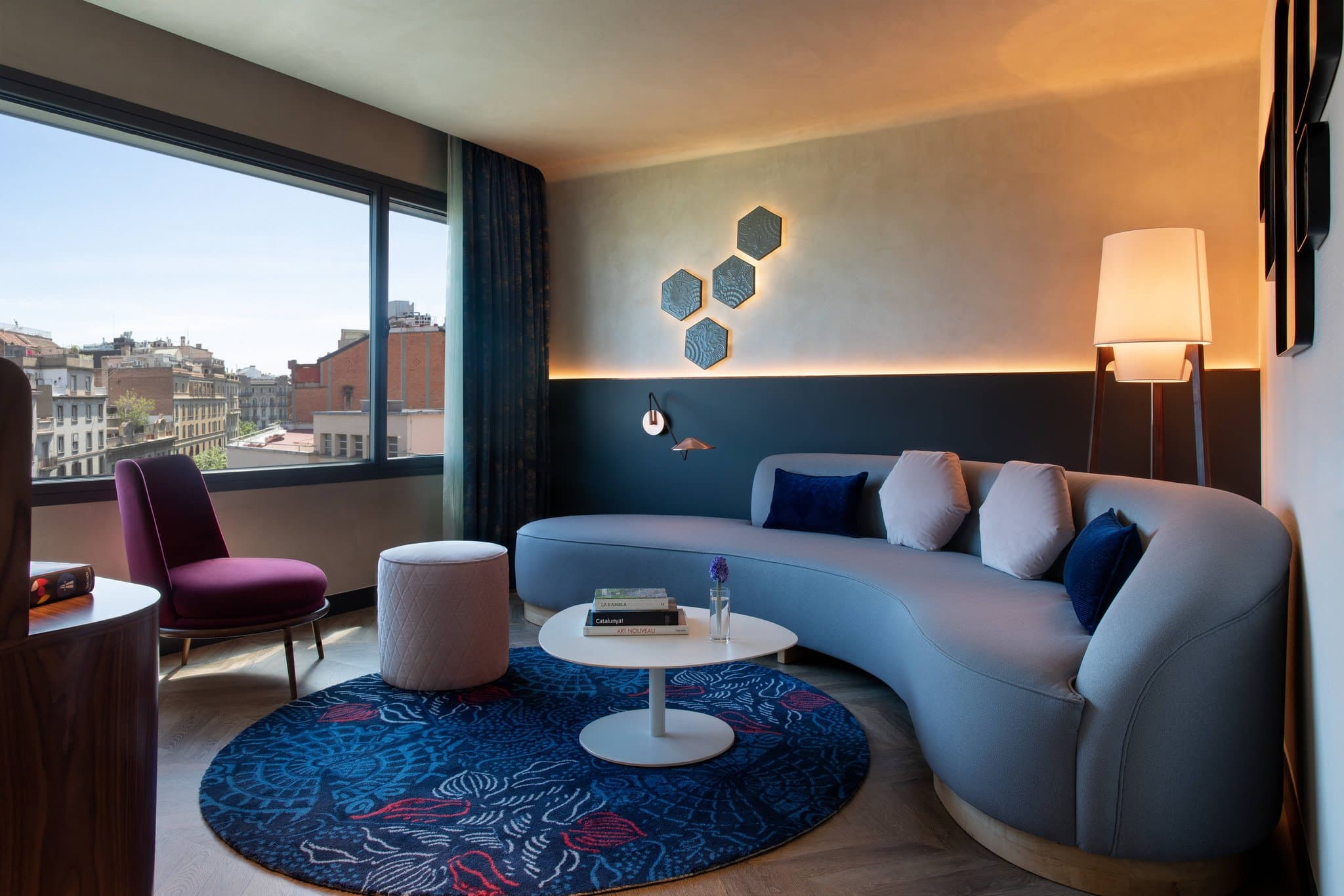 A twilight view from the Goja Rooftop at Renaissance Barcelona, featuring a lit plunge pool in the foreground and the illuminated spires of the Sagrada Família in the background.
