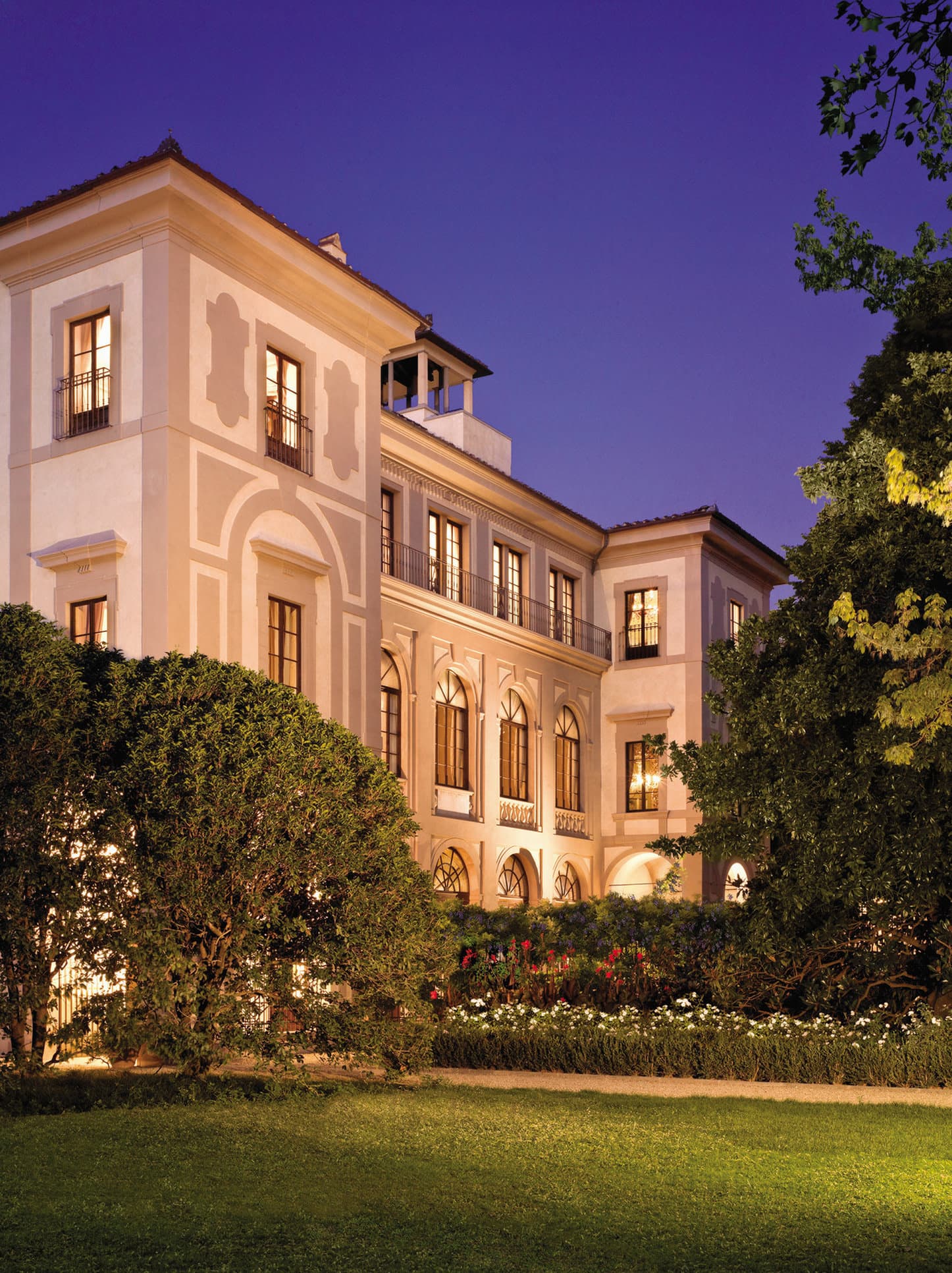 A serene view of the Four Seasons Firenze outdoor pool surrounded by the lush trees of the Giardino della Gherardesca.