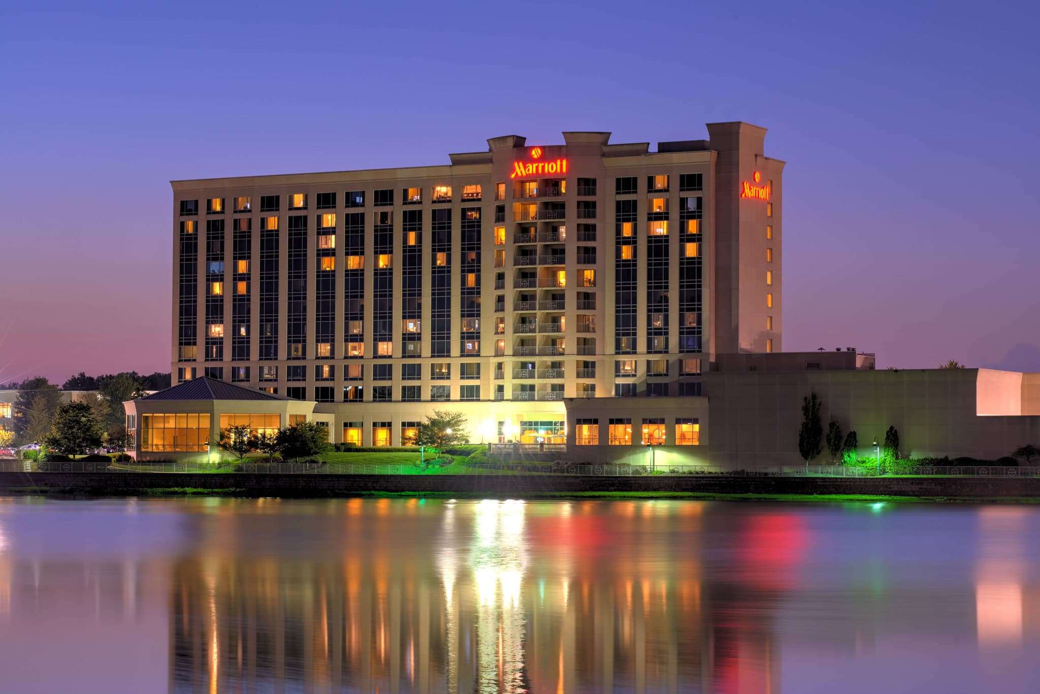 Marriott Indianapolis North lakeside exterior with walking trail and solarium reflected in the water.