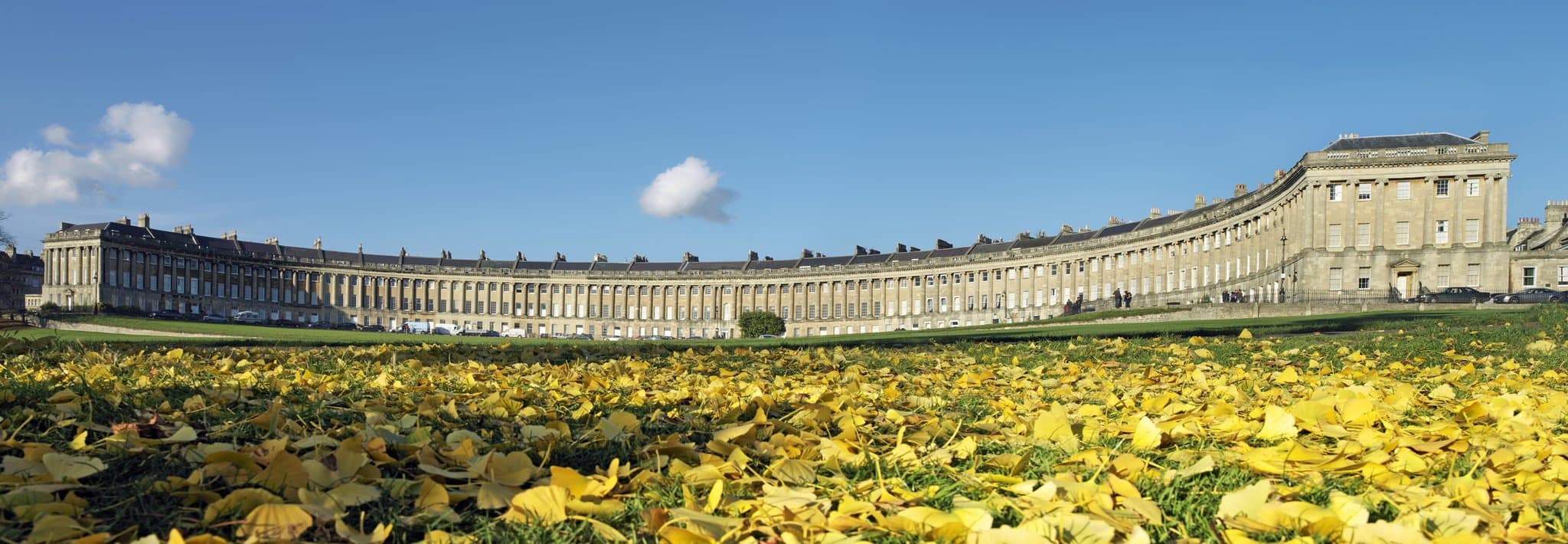 A view of the Royal Crescent Hotel's hidden one-acre garden showing the Wisteria Arch and guests dining on the terrace.