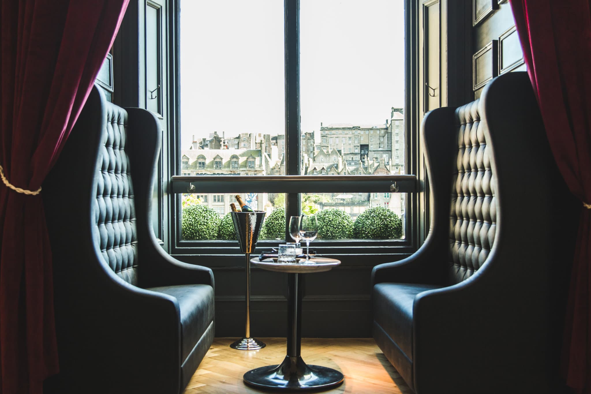 View of the Gothic Scott Monument from a Hotel Indigo Edinburgh room window, with plush Harris Tweed armchair in the foreground.