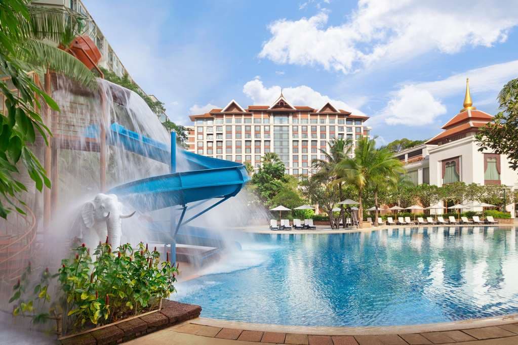 Aerial view of Shangri-La Chiang Mai's massive free-form pool surrounded by sun loungers and frangipani trees.