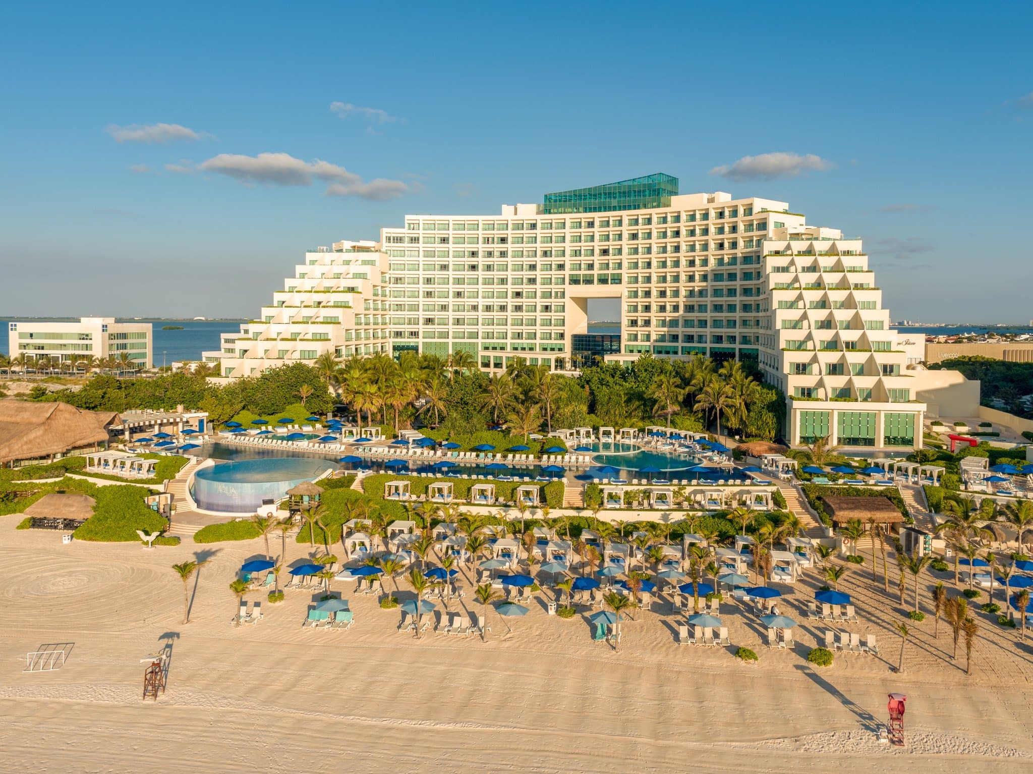 View from a Live Aqua Cancun suite balcony looking out over the seven pools and the Caribbean Sea.