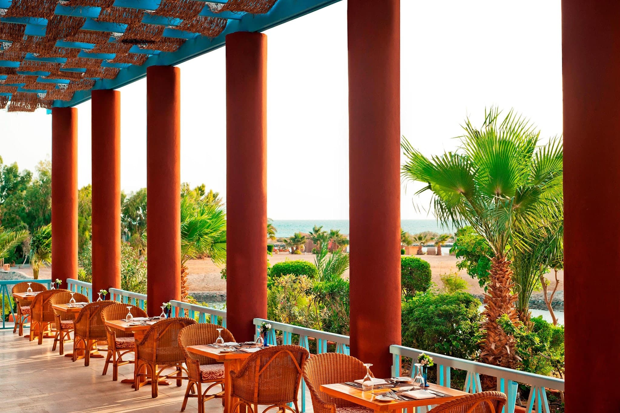 Sheraton Miramar El Gouna exterior showing Nubian-style domes and timber bridges over a turquoise lagoon.