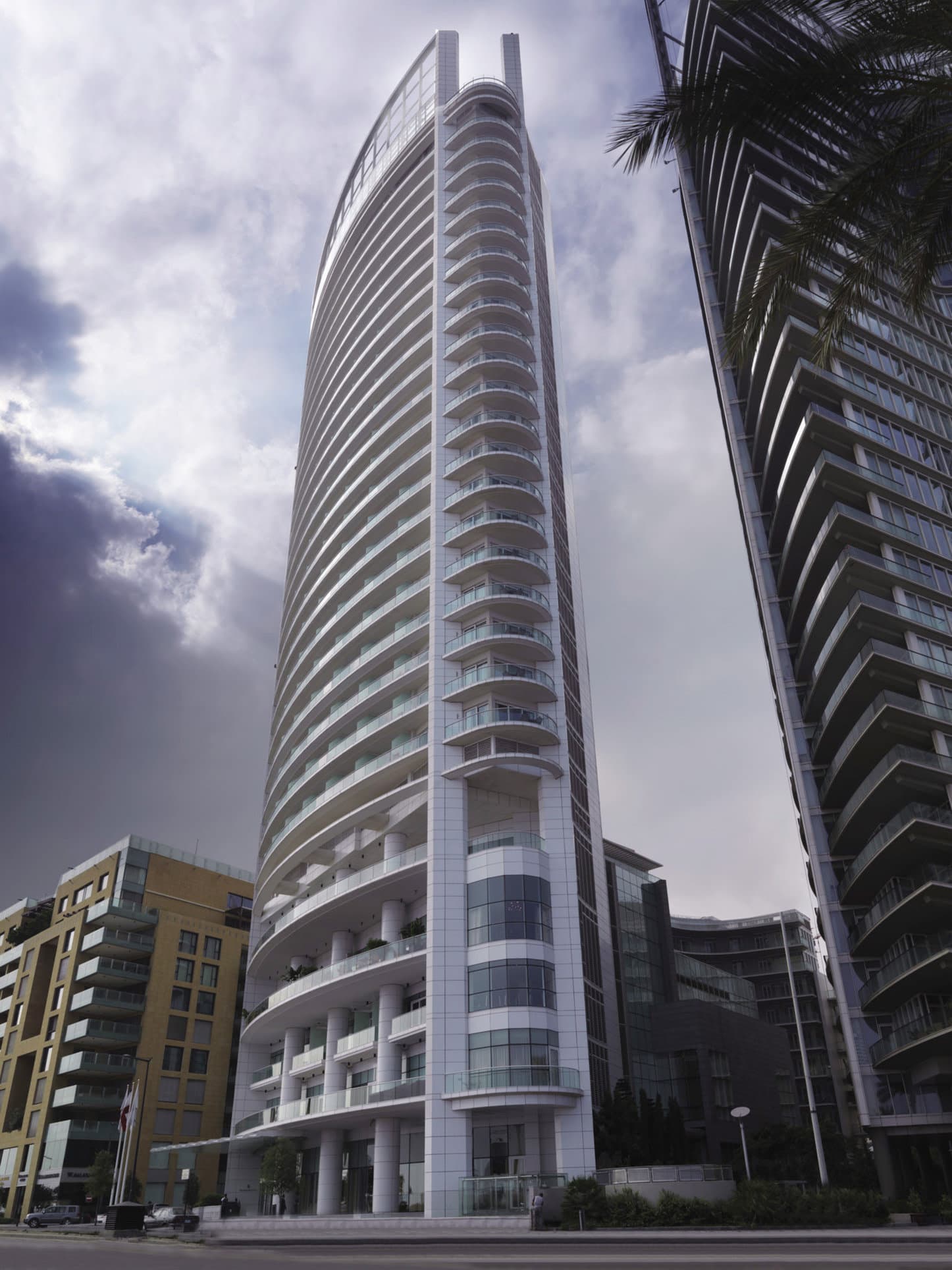 The towering glass facade of Four Seasons Beirut reflecting the blue Mediterranean sky, rising above the yachts of Zaitunay Bay.