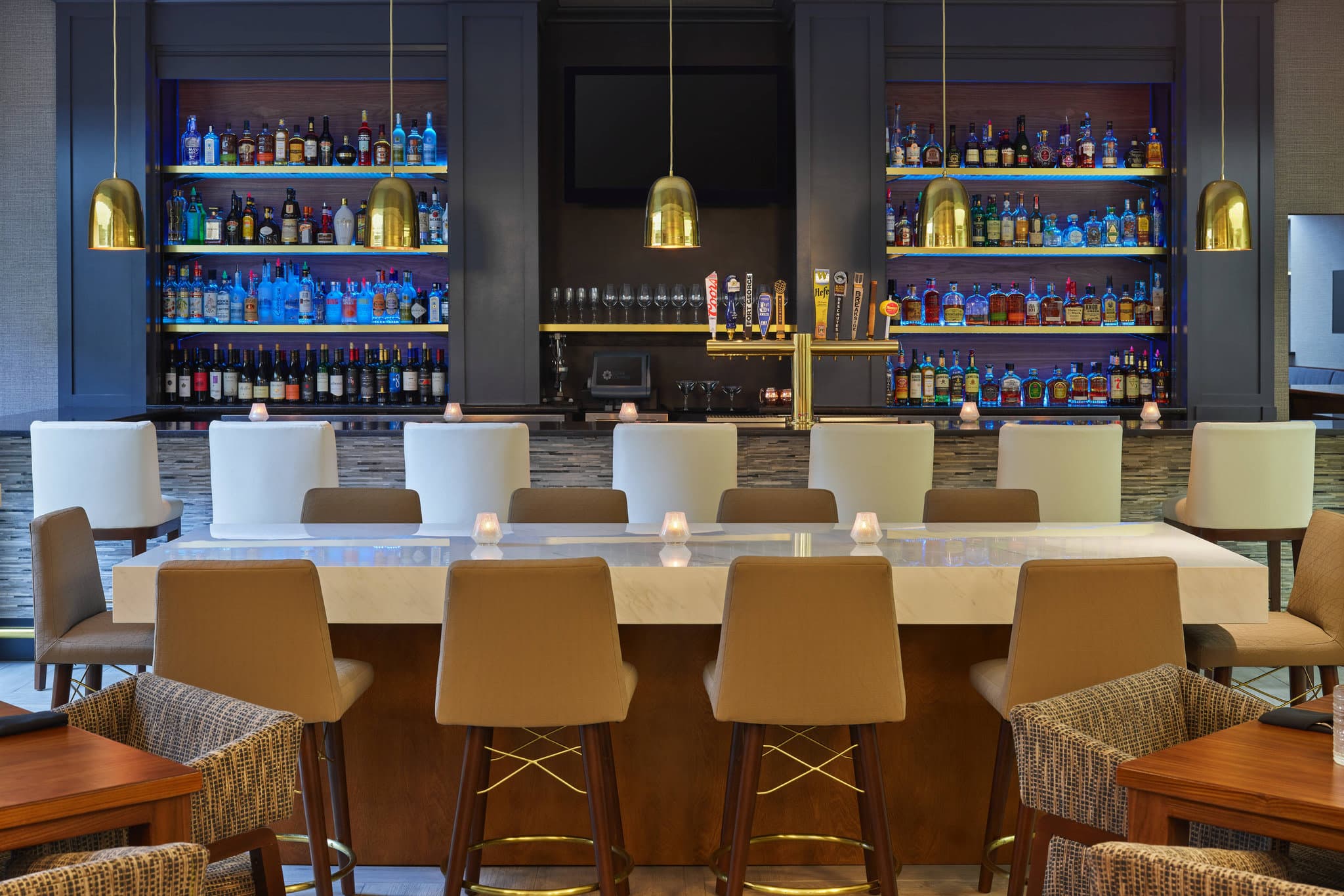 Lobby of Sheraton Portland Airport Hotel featuring mid-century modern furniture and a suspended art installation of Pacific Northwest icons.