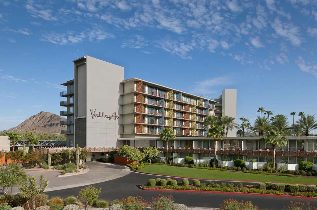 The iconic Hotel Valley Ho exterior featuring mid-century modern concrete breeze blocks and retro turquoise balconies against a bright blue Scottsdale sky.