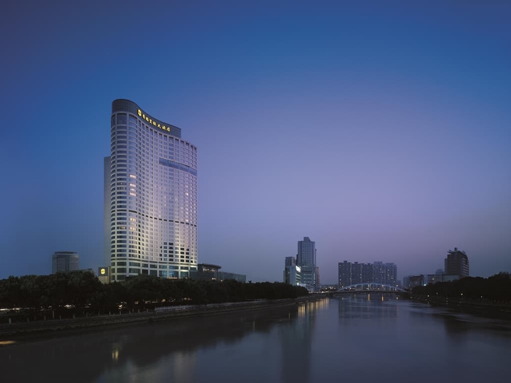 A sweeping view from a high-floor suite at Shangri-La Ningbo, overlooking the confluence of three rivers and the historic colonial architecture of the Old Bund at dusk.