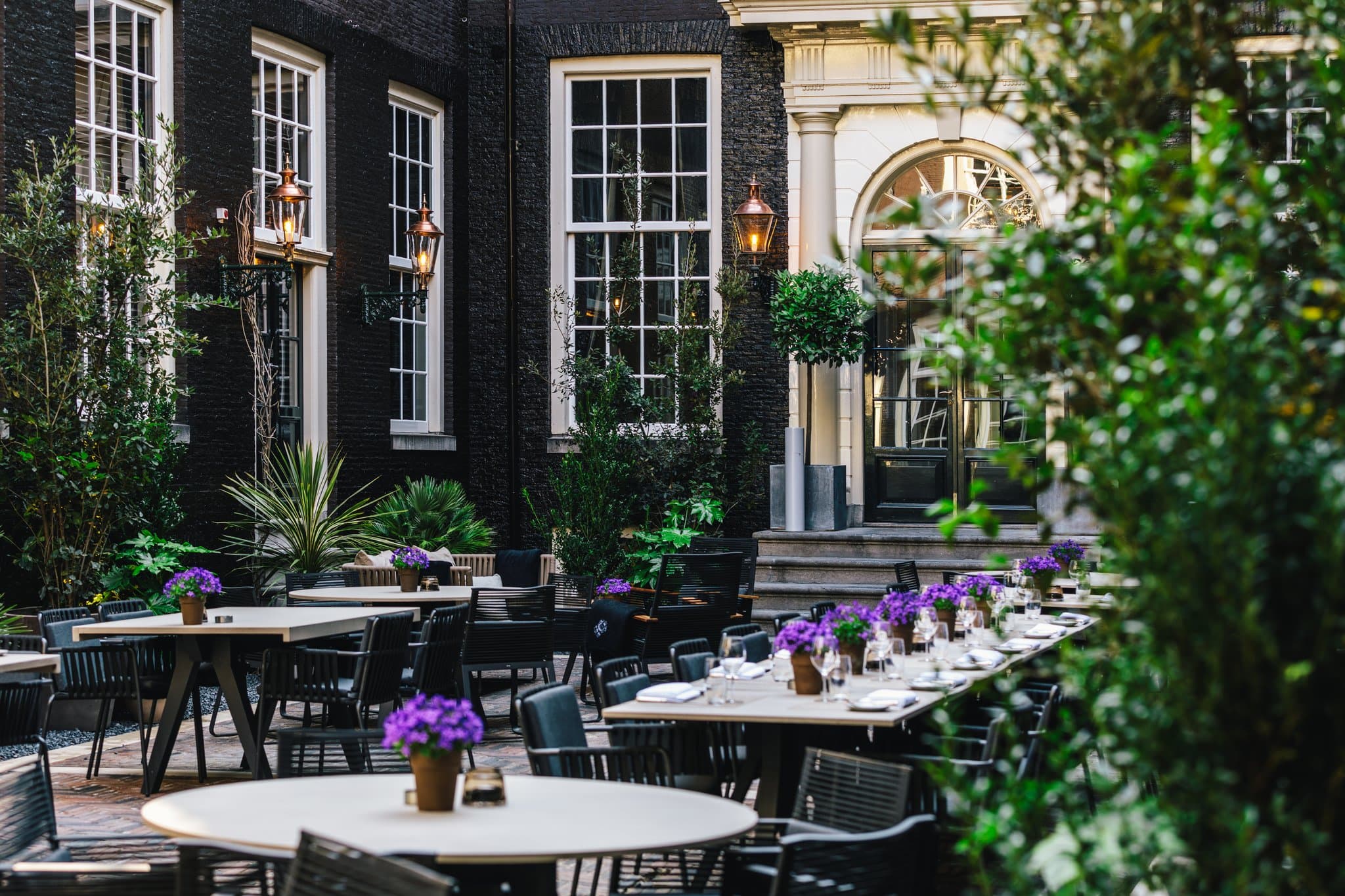 The Dylan Amsterdam's historic 17th-century stone archway entrance leading to a secluded courtyard.