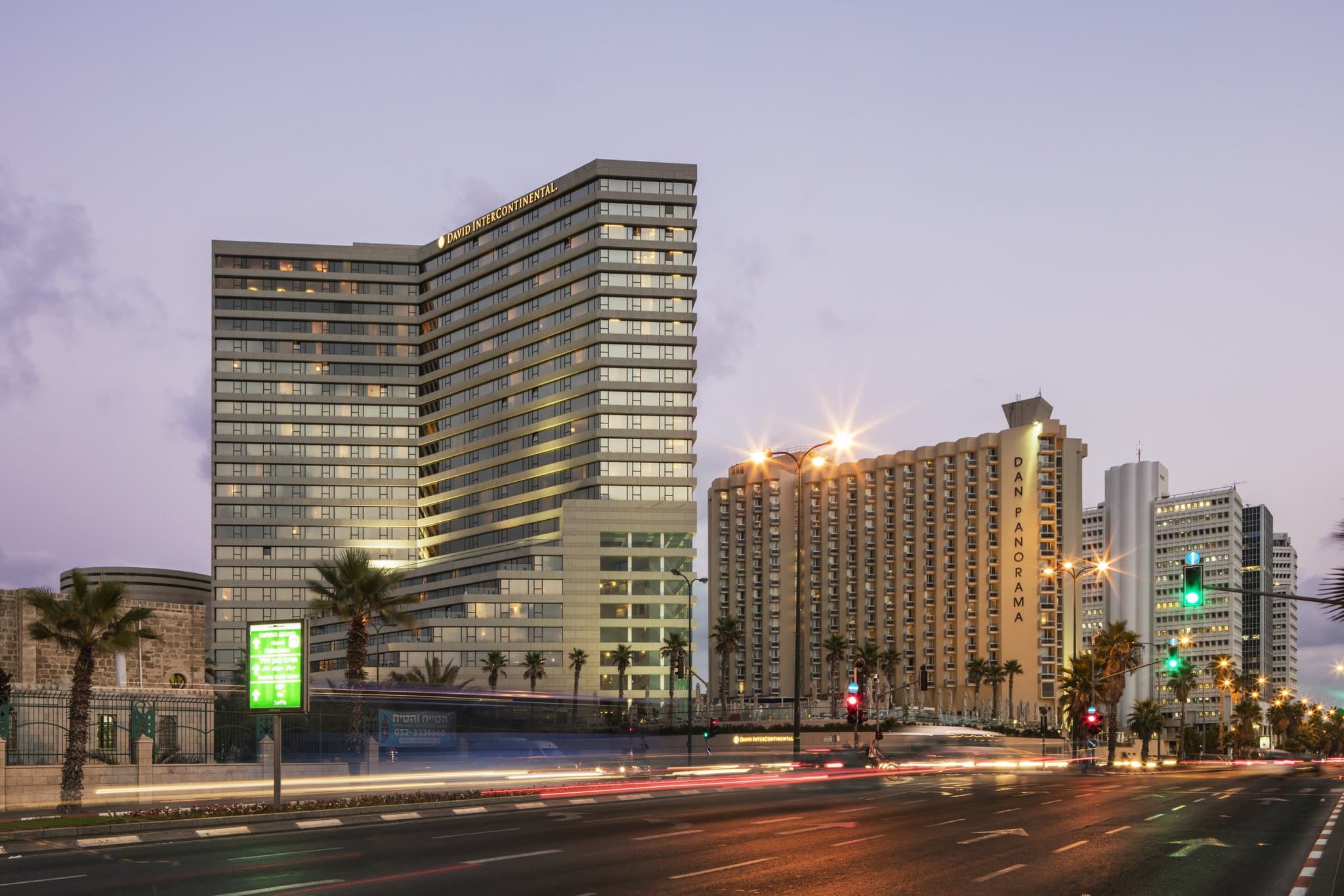 View of the InterContinental David Tel Aviv outdoor pool at sunset with the Mediterranean Sea in the background.