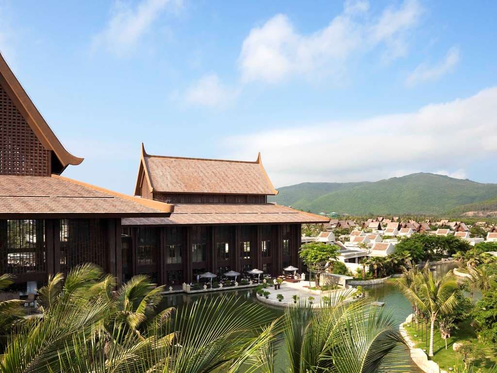 A secluded private pool in a Myanmar Villa at Pullman Sanya, framed by Nanyang-style reflecting eaves and lush tropical palms.