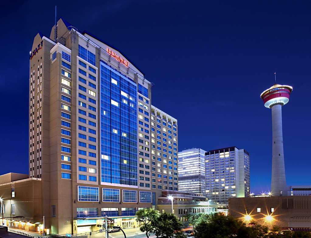 The 18th-floor indoor pool at Hyatt Regency Calgary featuring floor-to-ceiling windows with a skyline view of downtown Calgary.