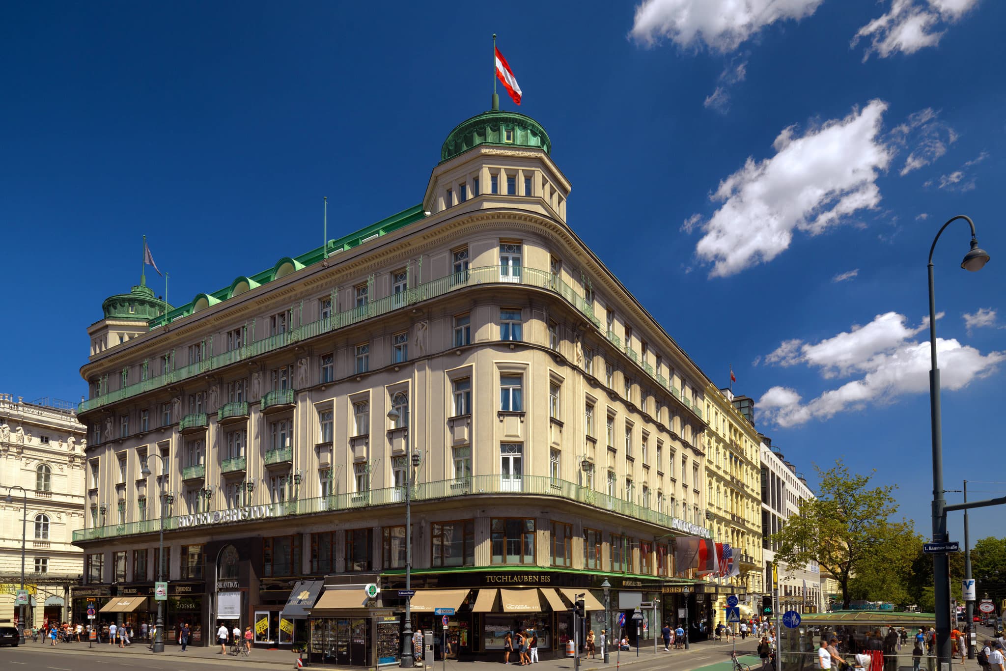 The Grand Staircase of Hotel Bristol Vienna featuring intricate brass railings and Art Deco architecture.