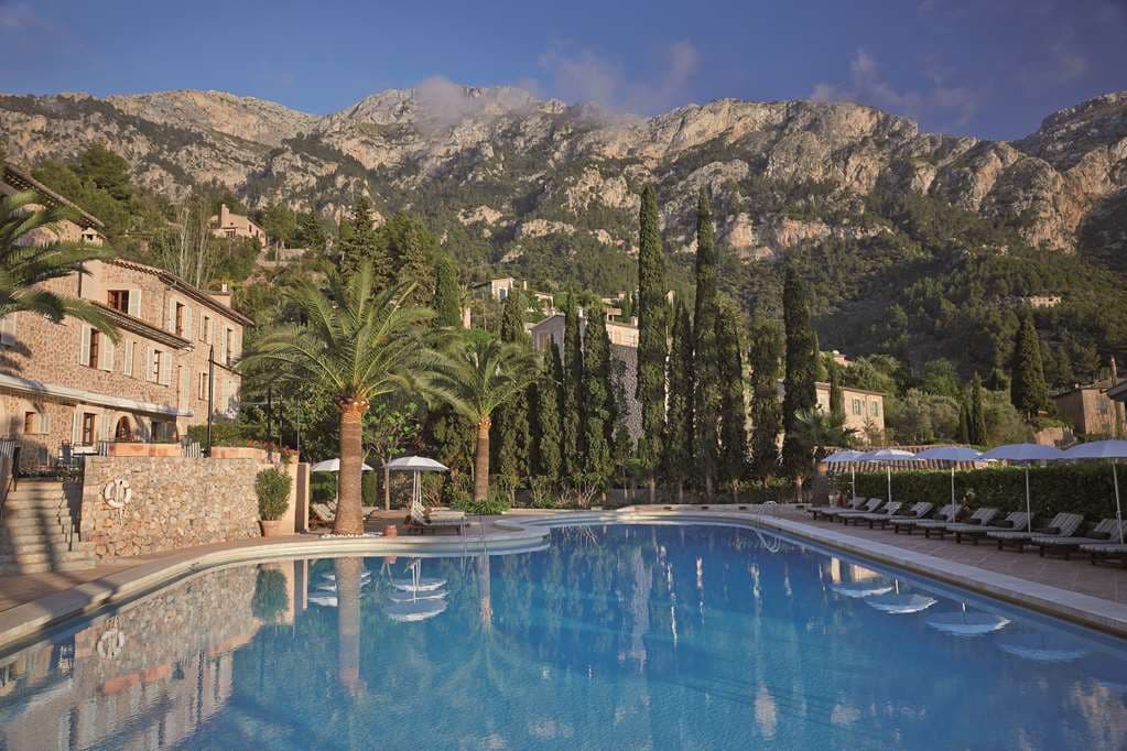 Candlelit dinner at El Olivo restaurant terrace at La Residencia, overlooking the Tramuntana mountains and Deià village at sunset.