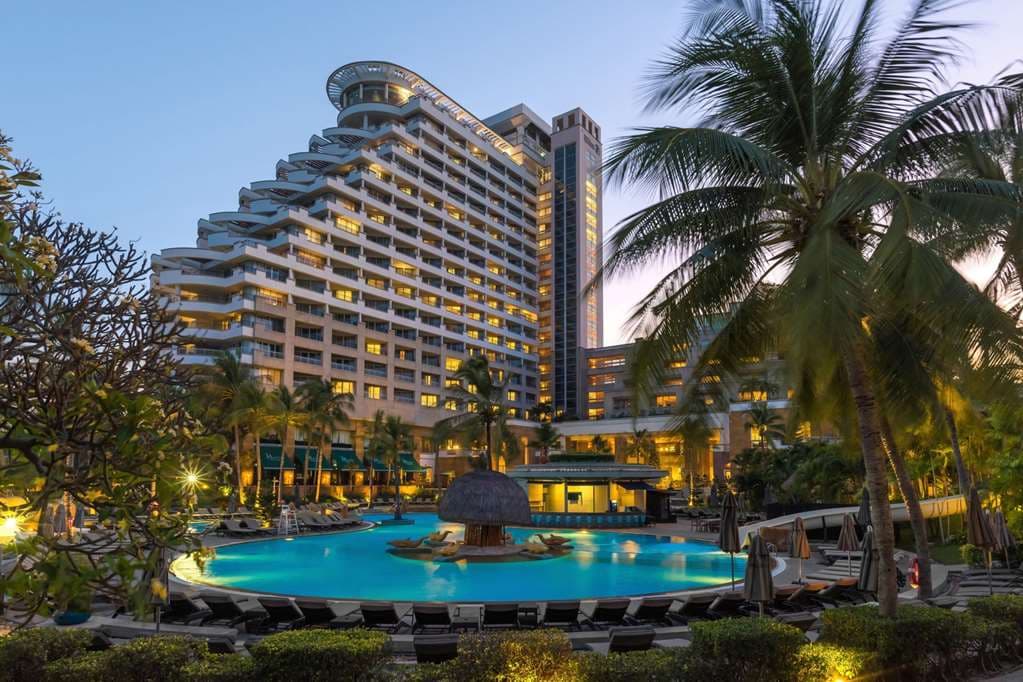 Aerial view of Hilton Hua Hin Resort & Spa featuring the large lagoon pool and the high-rise tower dominating the Hua Hin beachfront skyline.