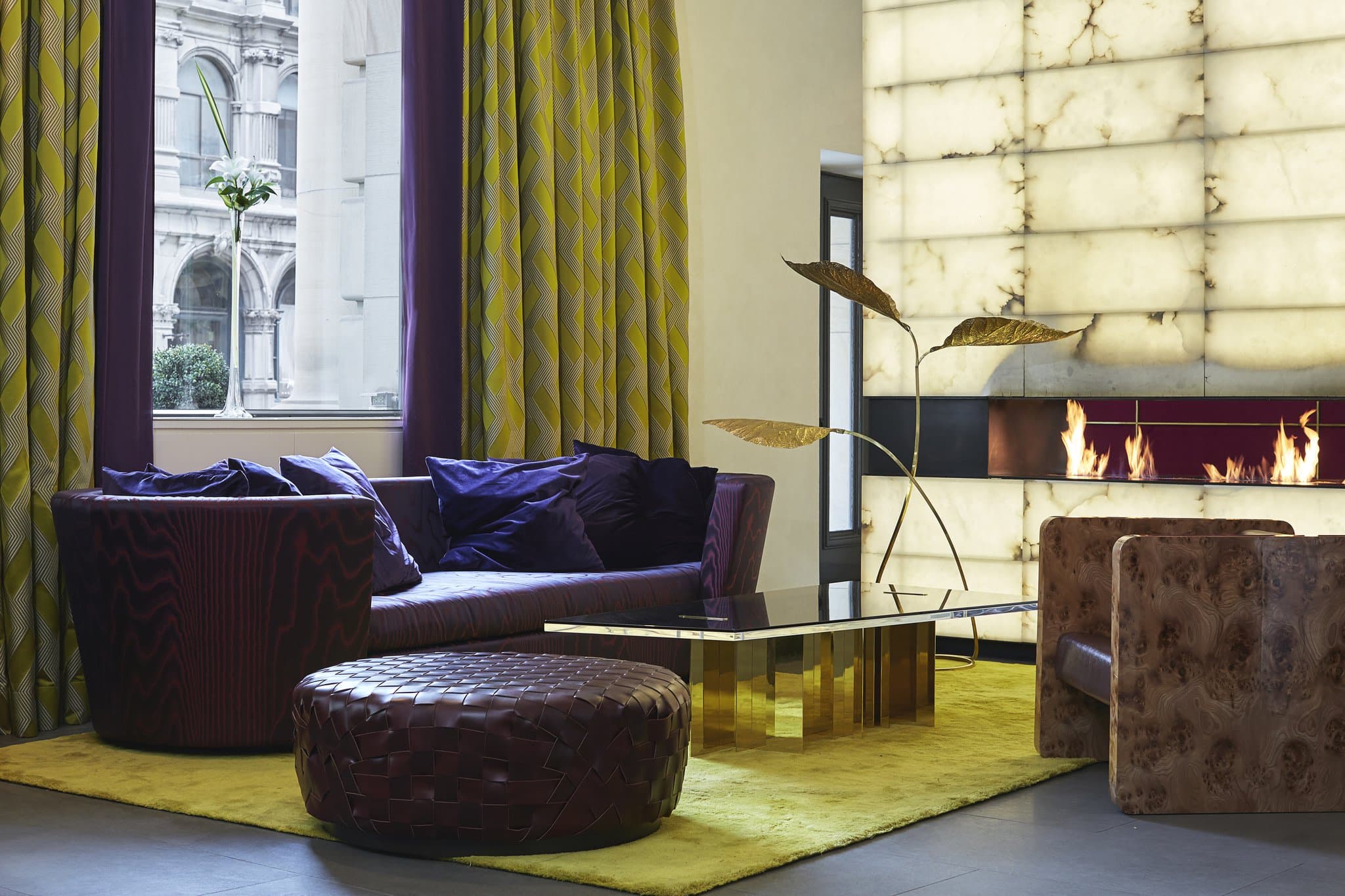 The glowing translucent alabaster fireplace in the Hotel St. Paul lobby, contrasting with dark minimalist furniture.