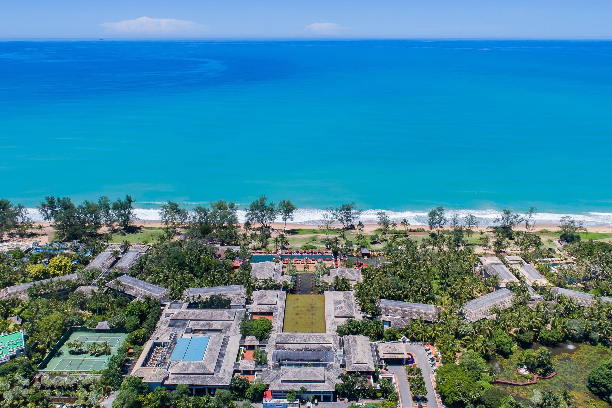 Sunset reflecting over the JW Marriott Phuket's iconic lobby lotus pond, leading the eye to the Andaman Sea.