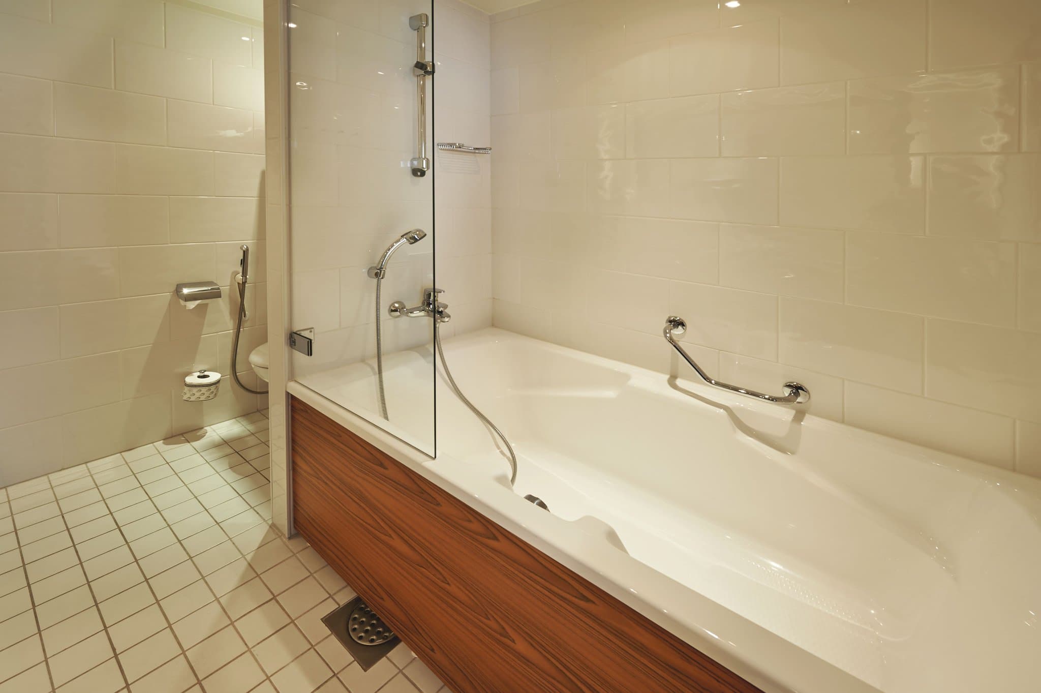 The sleek, mood-lit indoor swimming pool at Crowne Plaza Helsinki - Hesperia with stone lined walls and calm blue water.