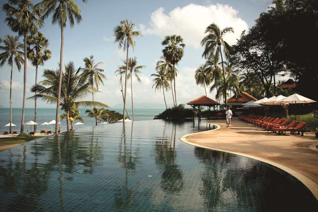 Napasai Belmond Koh Samui infinity pool overlooking the Gulf of Thailand at sunset with palm trees
