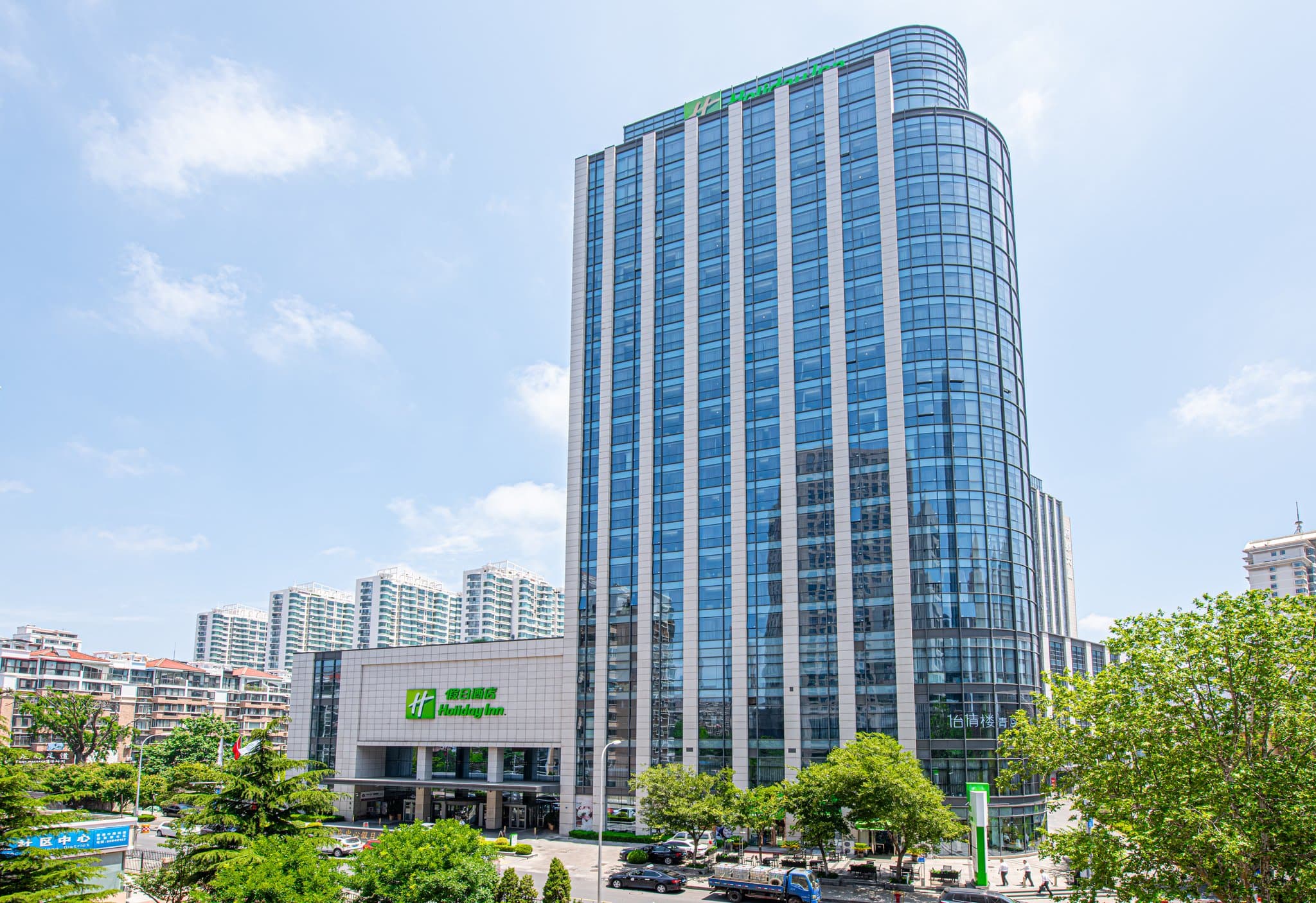 The geometric, heated indoor pool at Holiday Inn Qingdao City Centre with blue tiled lanes and modern ceiling lighting.