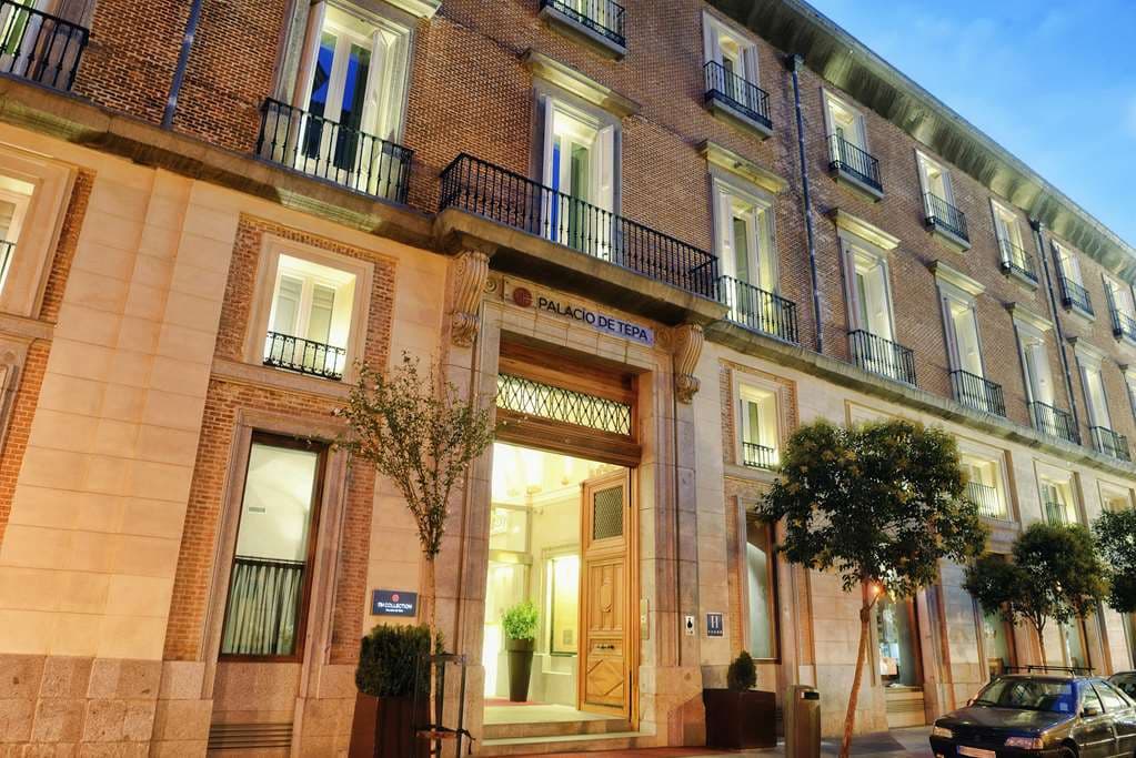 Lobby of NH Collection Madrid Palacio de Tepa featuring a glass floor revealing illuminated ancient canal ruins.