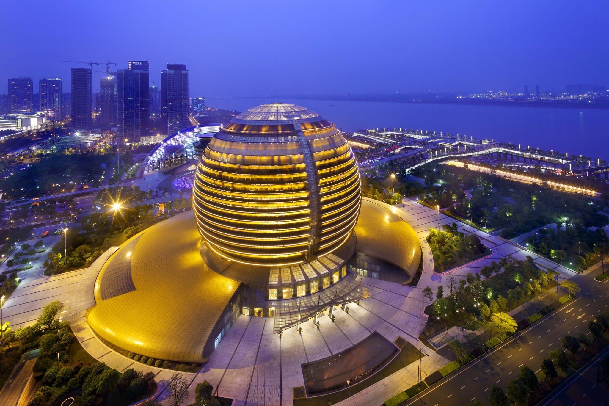 Low-angle interior shot of the InterContinental Hangzhou's massive golden atrium with circular corridors rising 18 floors.