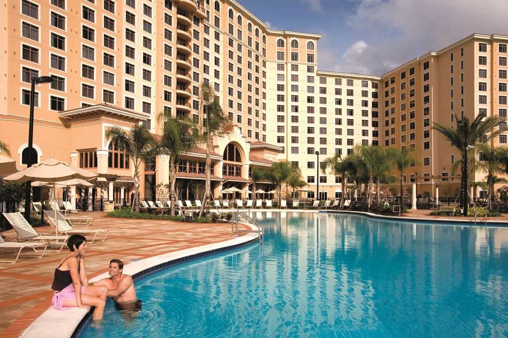 The 14-story Spanish Revival façade of Rosen Shingle Creek rising above a manicured golf course and palm trees.