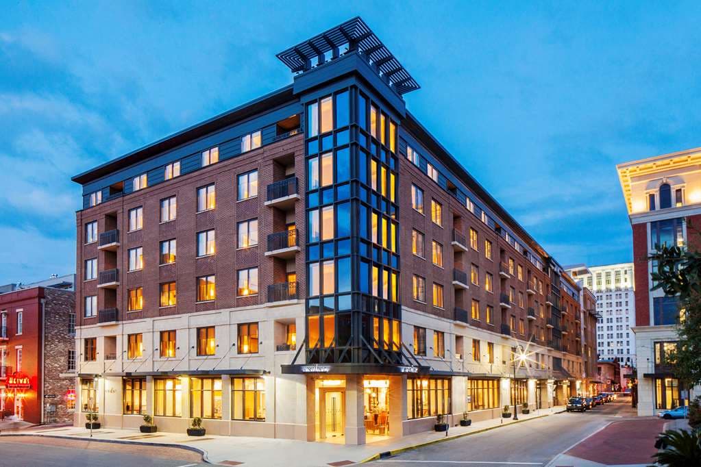 Twilight view of Andaz Savannah's second-floor pool terrace featuring illuminated fire pits and cabanas.