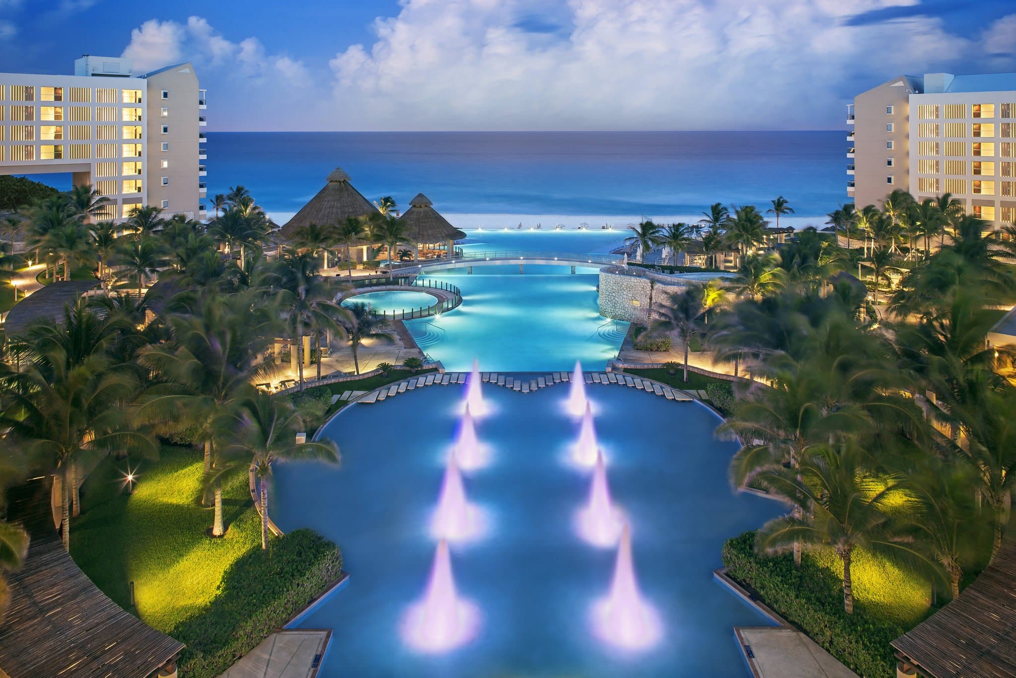 The Westin Lagunamar infinity pool edge blending into the Caribbean Sea with the Yamil Lu’um Mayan ruins visible in the background.