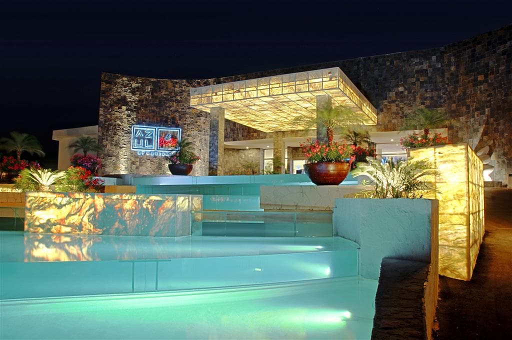 The Sky Deck at Iberostar Selection Riviera Cancun at sunset featuring white lounge seating and 360-degree ocean views.