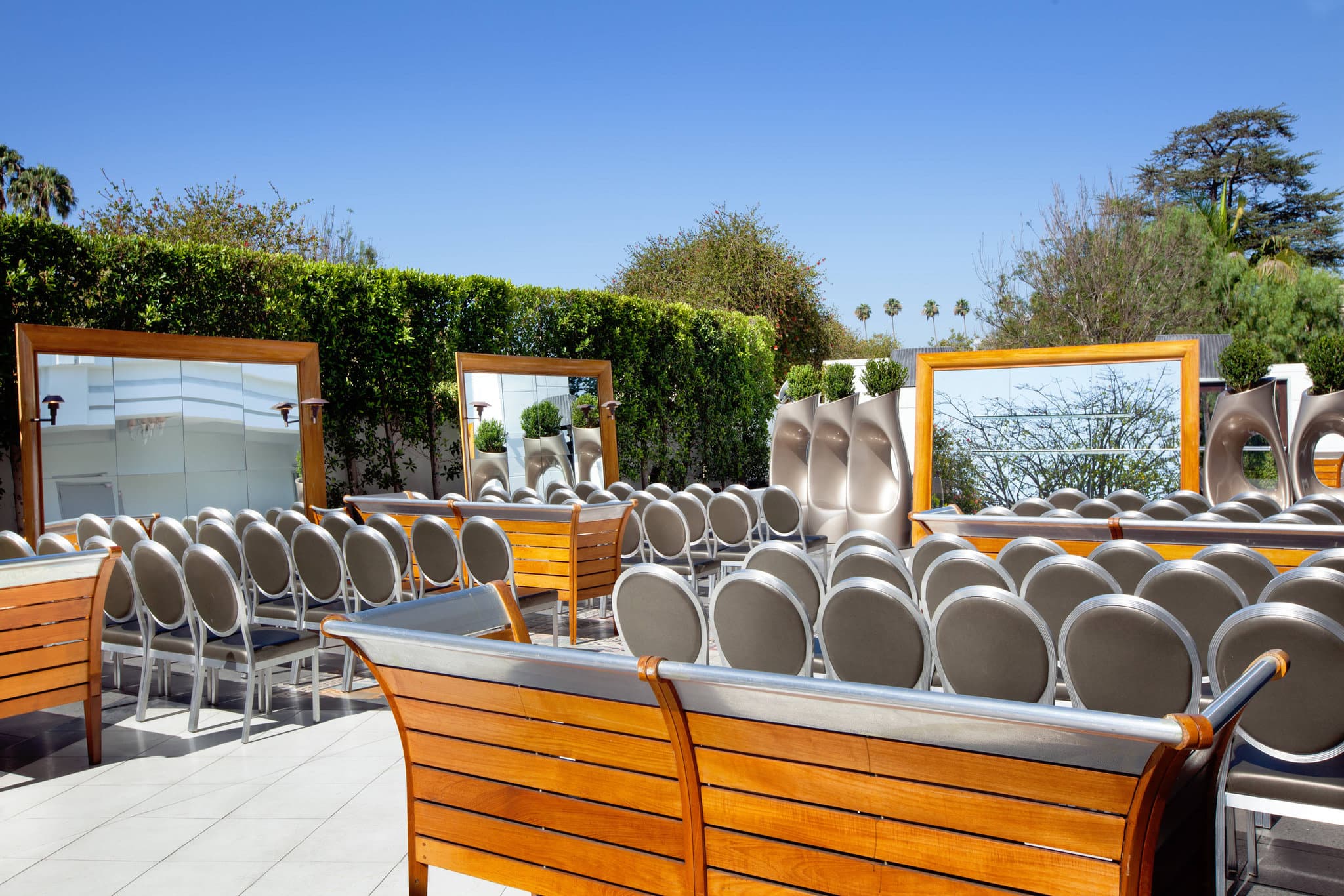 Rooftop pool deck at SLS Hotel Beverly Hills featuring silver sphere decor, white cabanas, and guests lounging under the Los Angeles sun.