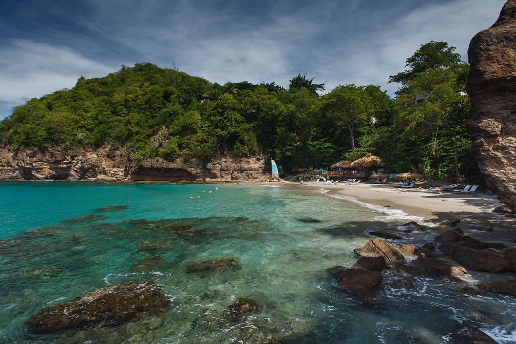 A wooden deck called Rock Maison at the base of a cliff at Cap Maison, with a champagne bucket arriving via zip-line.