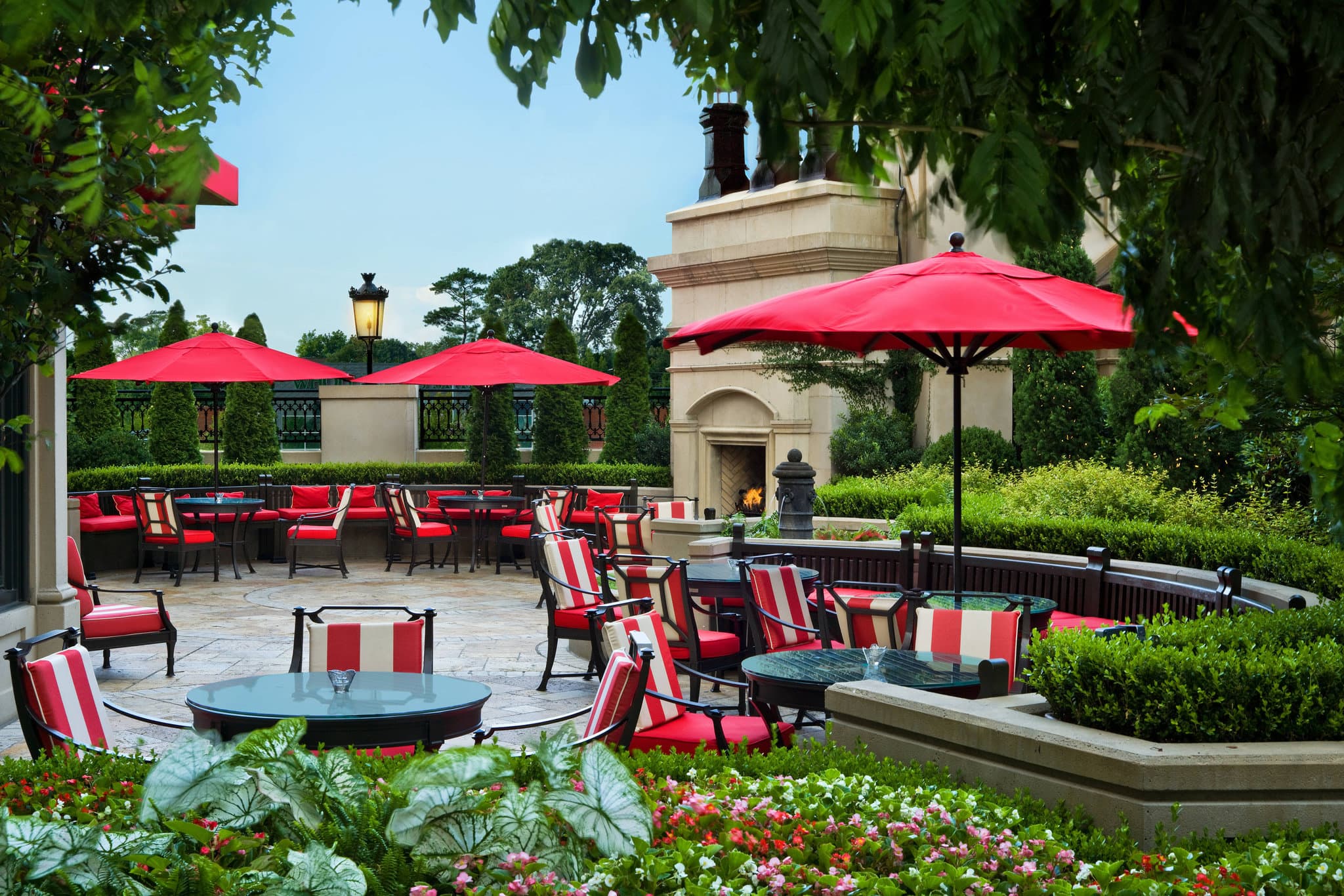 The St. Regis Atlanta's 'Pool Piazza' featuring a grand fountain and lounge chairs, surrounded by the hotel's classic architecture.