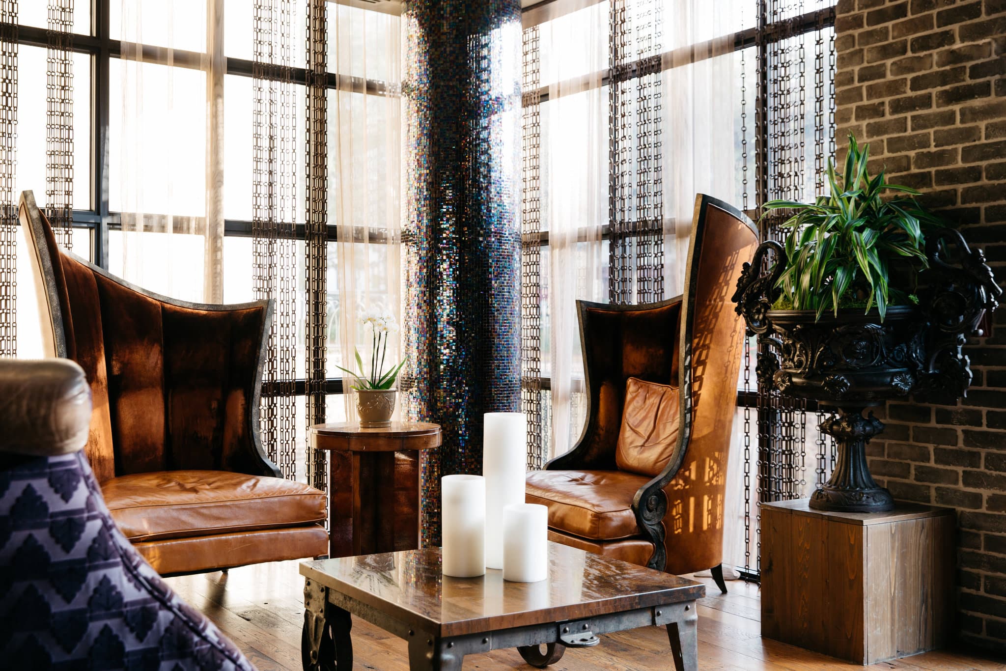 Lobby of The Bohemian Hotel Savannah Riverfront featuring large oyster shell chandeliers and rustic wooden decor.